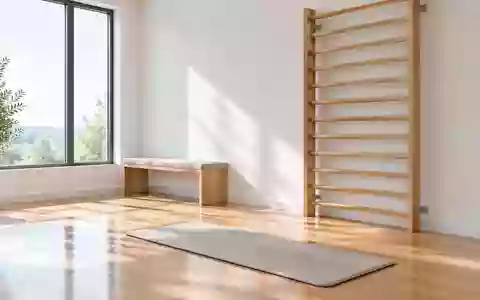Ein minimalistischer, heller Therapieraum mit einer Sprossenwand und einer Gymnastikmatte auf einem Holzboden. - Foto: über boerse-global.de