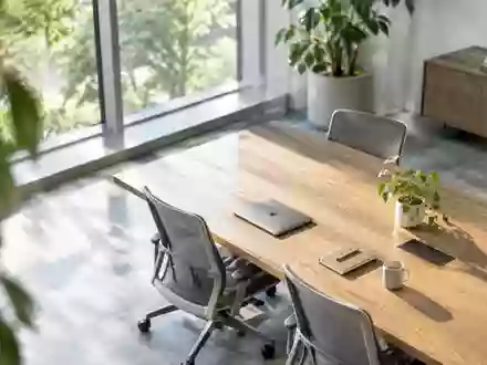 Ein minimalistischer, heller Büroarbeitsplatz mit einem leeren Besprechungstisch und ergonomischen Stühlen. - Foto: über boerse-global.de