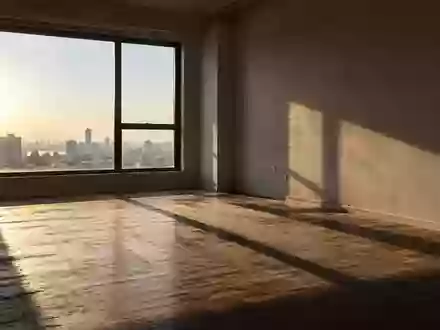Ein leerer, sonnendurchfluteter Wohnraum mit kahlen Wänden und Holzboden in einer minimalistischen Wohnung. - Foto: über boerse-global.de