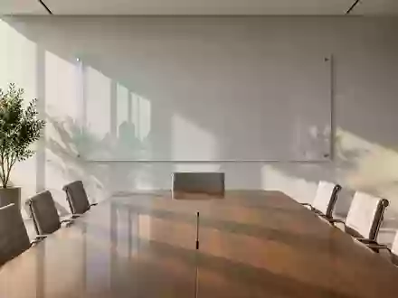 Ein minimalistischer, moderner Konferenzraum mit einem leeren Glasboard an der Wand und natürlichem Lichteinfall. - Foto: über boerse-global.de