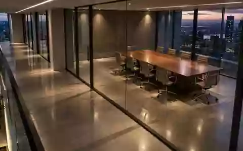 Ein minimalistisch gestalteter, moderner Büroflur mit Glaswänden und indirekter Beleuchtung in der Abenddämmerung. - Foto: über boerse-global.de
