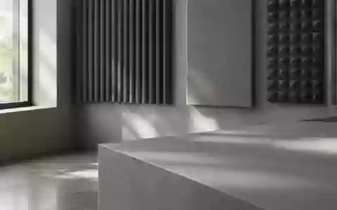 Ein minimalistisches, professionelles Tonstudio mit akustischen Wandpaneelen in neutralen Grautönen bei natürlichem Licht. - Foto: über boerse-global.de