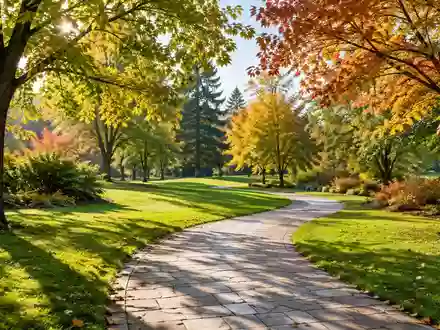 Ein sonniger, gepflasterter Weg in einem ruhigen Park mit grünen Wiesen und Bäumen im Herbstlicht. - Foto: über boerse-global.de
