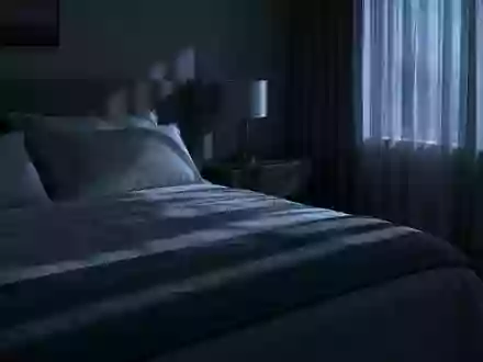 Ein ruhig wirkendes Schlafzimmer bei Nacht mit gedimmtem Licht und sanftem Mondschein, der durch die Vorhänge fällt. - Foto: über boerse-global.de