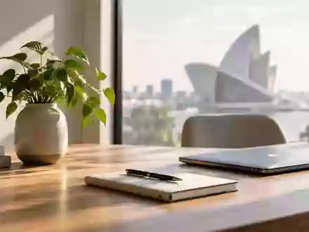 Ein minimalistischer Arbeitsbereich mit einem Holztisch und einer Pflanze bei natürlichem Tageslicht. - Foto: über boerse-global.de