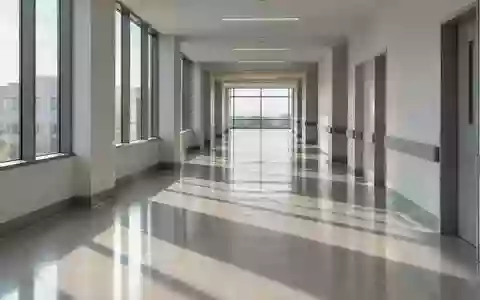 Ein minimalistischer, leerer Krankenhausflur mit sanftem Lichteinfall und klaren architektonischen Linien. - Foto: über boerse-global.de