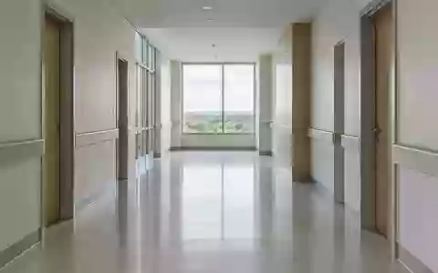 Ein leerer, in ruhiges Tageslicht getauchter Krankenhausflur mit minimalistischer Architektur. - Foto: über boerse-global.de