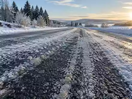 Mit Schnee und Schneematsch bedeckte Straßenoberfläche im Winter bei natürlichem Tageslicht. - Foto: über boerse-global.de