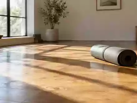 Eine aufgerollte Yogamatte auf einem hellen Holzboden in einem lichtdurchfluteten Raum. - Foto: über boerse-global.de