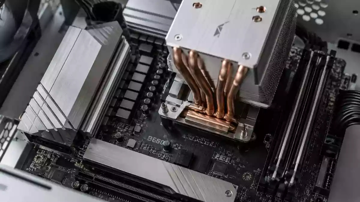 Nahaufnahme einer modernen Computer-Hauptplatine mit metallischen Kühlkörpern in einem minimalistischen Gehäuse. Illustration mit AI erstellt.