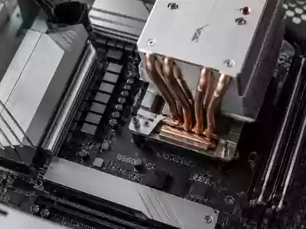 Nahaufnahme einer modernen Computer-Hauptplatine mit metallischen Kühlkörpern in einem minimalistischen Gehäuse. - Foto: über boerse-global.de