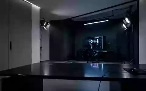 Ein minimalistisch eingerichtetes Gaming-Zimmer mit stimmungsvoller Beleuchtung und dunklen Oberflächen. - Foto: über boerse-global.de
