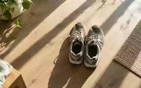 Ein Paar getragene Sportschuhe auf einem hölzernen Boden in einem sonnendurchfluteten Raum, symbolisch für Beständigkeit. - Foto: über boerse-global.de