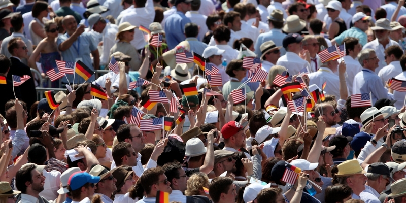 Zuschauer mit FÃ¤hnchen der USA und Deutschlands vor dem Brandenburger Tor in Berlin - Foto: über dts Nachrichtenagentur