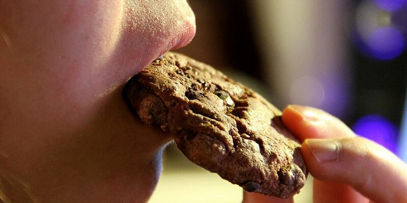 Junges Mädchen isst einen Schokoladenkeks (Archiv) - Foto: über dts Nachrichtenagentur