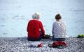 Alte und junge Frau sitzen am Strand - Foto: über dts Nachrichtenagentur