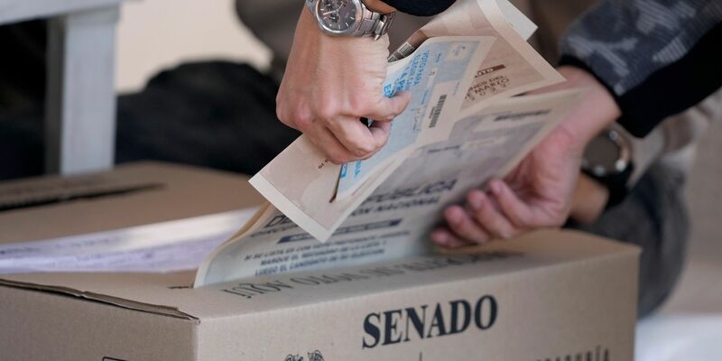Ein schlammbedeckter Lastwagen steht nach einem Erdrutsch unter einer Brücke. - Foto: Fernando Vergara/AP/dpa