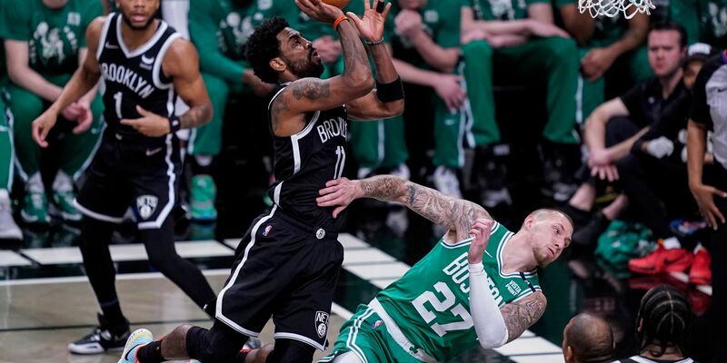 Kyrie Irving (M, l) von Brooklyn foult Daniel Theis (M, r) von Boston. - Foto: John Minchillo/AP/dpa