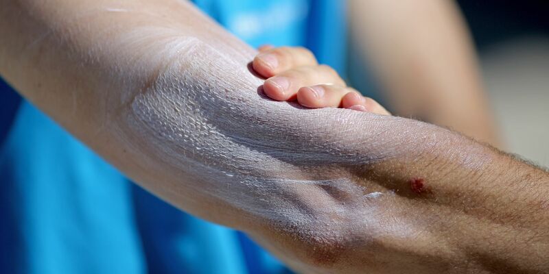 Ein Mann verreibt Sonnencreme auf seinem Arm. Einer aktuellen Umfrage zufolge nutzt gut ein Drittel aller Befragten im Frühjahr und Sommer normalerweise kein Sonnenschutzmittel. - Foto: Jan Woitas/dpa-Zentralbild/dpa