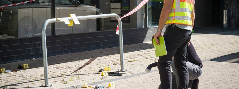 Ermittler der Spurensicherung arbeiten in der Innenstadt von Hanau vor dem Hochhaus, in dem das tote Mädchen gefunden wurde. Auf der Straße lag der schwer verletzte Junge. - Foto: Frank Rumpenhorst/dpa