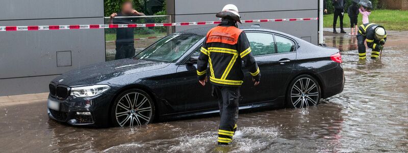Ein Auto steht in Hamburg-Öjendorf auf einer von starkem Regen überfluteten Straße im Wasser. - Foto: Daniel Bockwoldt/dpa
