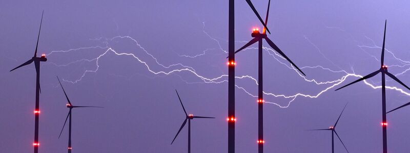 Ein Blitz erhellt den Nachthimmel über Windenergieanlagen im brandenburgischen Jacobsdorf. - Foto: Patrick Pleul/dpa