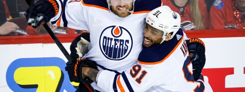 Leon Draisaitl von den Edmonton Oilers wird von Gustav Forsling von den Florida Panthers an die Bande gecheckt. - Foto: Jeff Mcintosh/The Canadian Press/AP/dpa