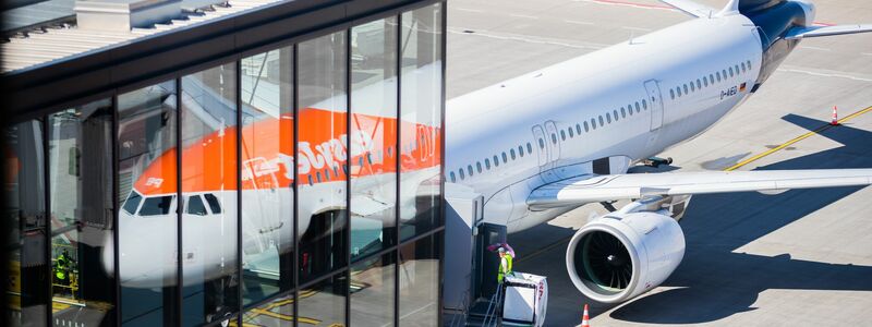 Passagiere stehen am Flughafen Berlin Brandenburg (BER) vor der Sicherheitskontrolle Schlange (Archivbild). - Foto: Christoph Soeder/dpa