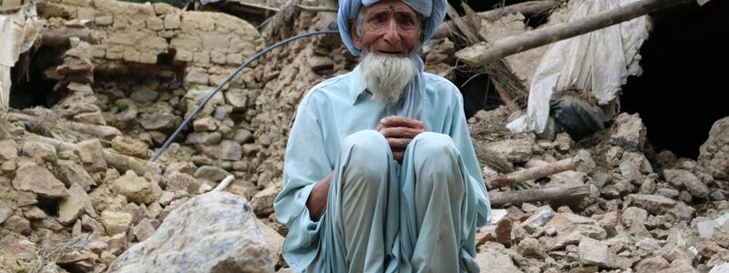 Ein Mann sitzt vor den Trümmern seines Hauses in Chost, das bei dem schweren Erdbeben zerstört wurde. - Foto: Uncredited/AP/dpa