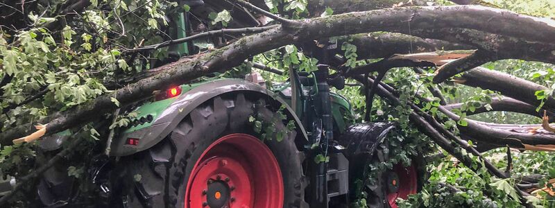 In Mönchengladbach ist ein Baum auf einen Traktor gestürzt. - Foto: Sascha Rixkens/Einsatzreporter Niederrhein/dpa