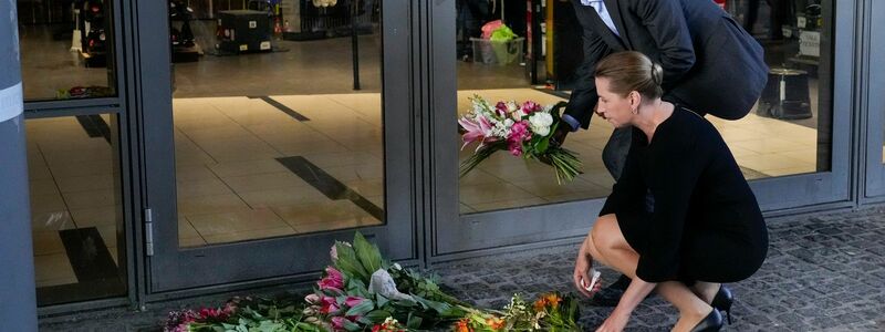Dänemarks Ministerpräsidentin Mette Frederiksen legt Blumen am Eingang des Einkaufszentrums Field's nieder. - Foto: Sergei Grits/AP/dpa