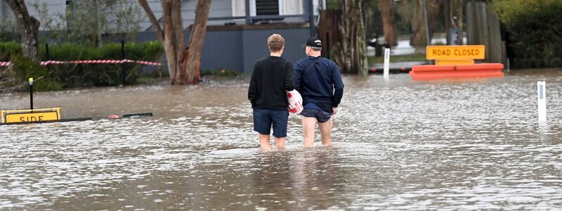 Anwohner waten durch das Hochwasser. - Foto: Jeremy Piper/AAP/dpa
