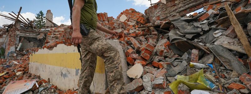 Rettungskräfte arbeiten an einem zerstörten Gebäude in Charkiw. - Foto: Andrii Marienko/AP/dpa