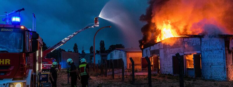 Einsatzkräfte der Feuerwehr versuchen, einen Gebäudebrand in der Region Falkenberg /Elster zu löschen. - Foto: Frank Hammerschmidt/dpa