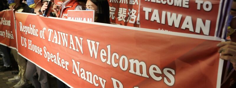 Unterstützerinnen und Unterstützer mit großen Willkommens-Bannern für Nancy Pelosi. - Foto: Chiang Ying-Ying/AP/dpa