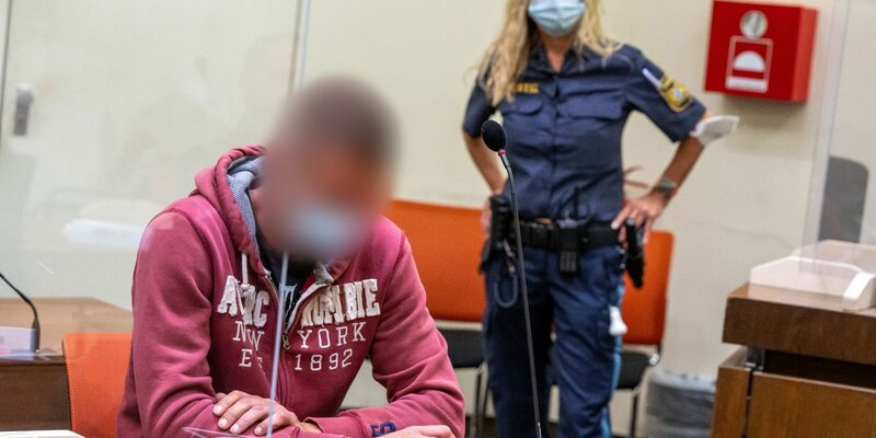Der Angeklagte wird von der Polizei in den Gerichtssaal geführt. - Foto: Peter Kneffel/dpa