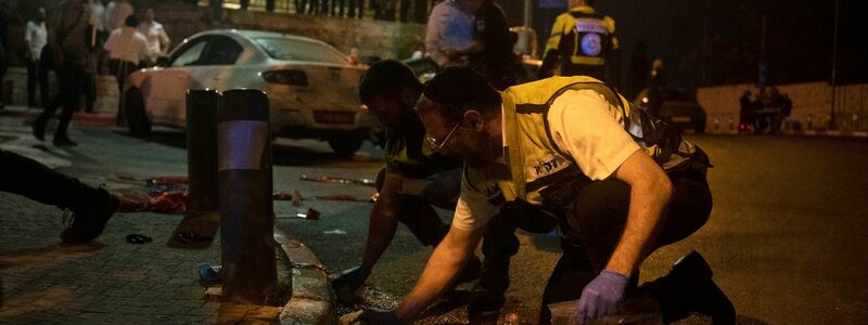 Freiwillige des Zaka-Rettungsdienstes säubern den Schauplatz mehrerer Schüsse, bei dem mehrere Israelis in der Nähe der Altstadt von Jerusalem verletzt wurden. - Foto: Maya Alleruzzo/AP/dpa