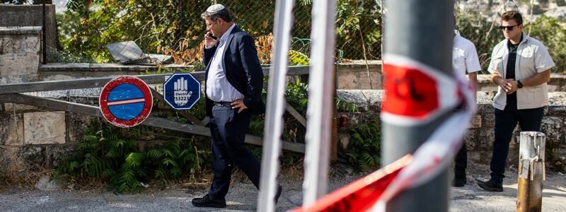Itamar Ben-Gvir, Vorsitzender der israelischen rechtsextremen Partei Otzma Yehudit, telefoniert während seines Besuchs am Tatort. - Foto: Ilia Yefimovich/dpa