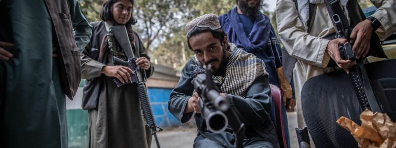 Ein junger Taliban-Kämpfer zielt zum Spaß mit seinem Gewehr in Richtung Fotograf, während er vor einer Polizeistation in Kabul Wache hält. - Foto: Oliver Weiken/dpa