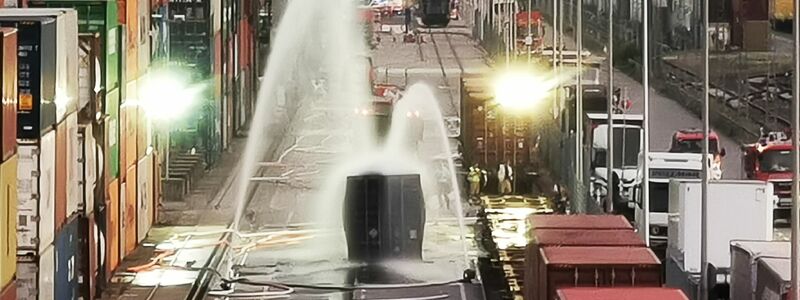 Nach einem Chemieunfall im Mühlauhafen kühlt die Feuerwehr einen Container, der mit rund 200 Fässern Hydrosulfit gefüllt ist. - Foto: Dieter Leder/dpa