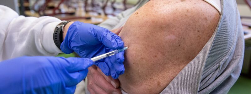 Ein Mann erhält in einem temporären mobilen Impfzentrum in Erlangen eine Auffrischungsimpfung gegen Covid-19. - Foto: Daniel Karmann/dpa