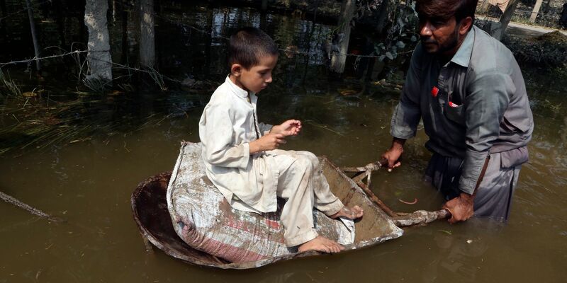 Starke Regenfälle haben die Straßen im pakistanischen Peschawar überschwemmt. In Pakistan sind bei für diese Jahreszeit ungewöhnlich starken Regenfällen mehrere Menschen ums Leben gekommen. - Foto: Muhammad Sajjad/AP/dpa