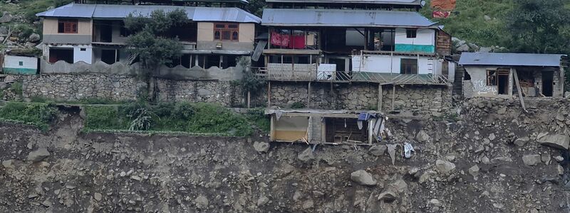 Von den Fluten zerstörte Häuser am Rand einer Klippe. - Foto: Sherin Zada/AP/dpa