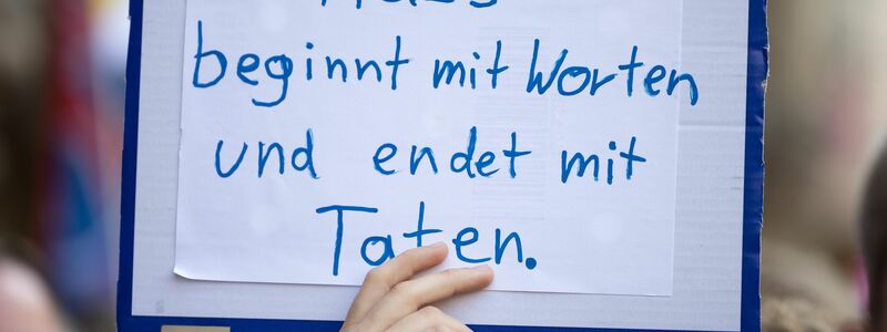 Ein Demonstrant hält in Münster ein Plakat gegen queerfeindlichen Hass in die Luft. - Foto: Friso Gentsch/dpa