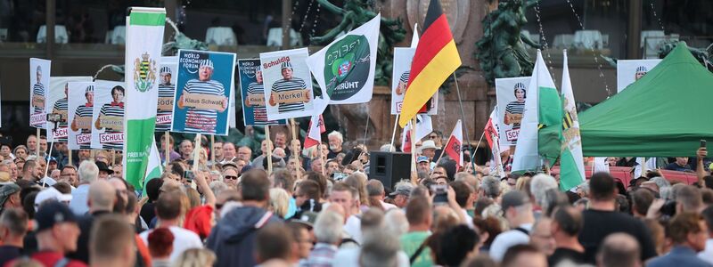 Teilnehmer der rechtsextremen und verschwörungsideologischen Demonstration, zu der die Partei «Freie Sachsen» aufgerufen hatte. - Foto: Jan Woitas/dpa