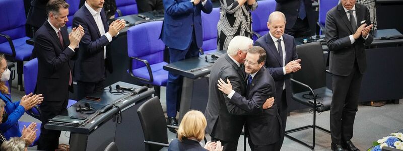 Bundespräsident Frank-Walter Steinmeier und der israelische Präsident Izchak Herzog (M.r.) umarmen sich nach Herzogs Rede. - Foto: Kay Nietfeld/dpa