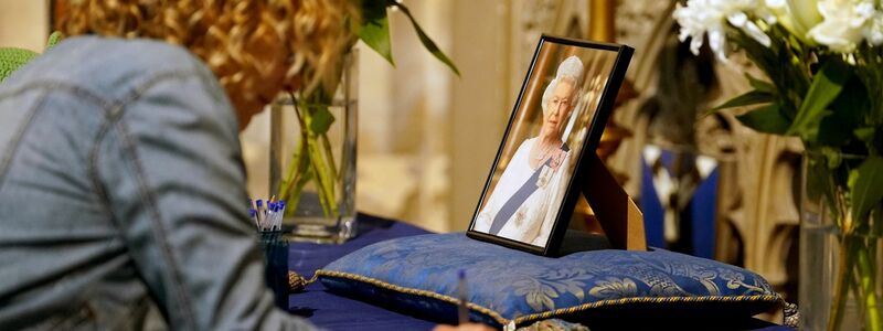 Trauernde tragen sich nach dem Tod von Königin Elizabeth II. in der Kathedrale von Canterbury in Kent in das Kondolenzbuch ein. - Foto: Gareth Fuller/PA Wire/dpa