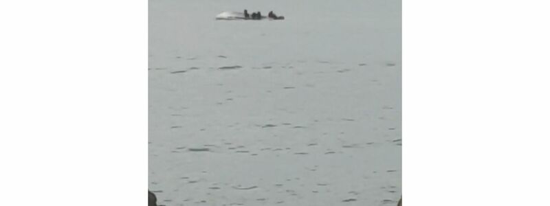 Überlebende klammern sich an den Rumpf eines gekenterten Bootes vor der Küste von Kaikoura. - Foto: Str/STR/dpa