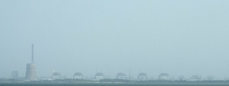 Ein Blick auf das Kernkraftwerk Saporischschja und den Fluss Dnipro auf der anderen Seite von Nikopol, Ukraine. Das Atomkraftwerk Saporischschja ist nach ukrainischen Angaben vollständig vom Stromnetz abgekoppelt worden und wird heruntergefahren. - Foto: Evgeniy Maloletka/AP/dpa