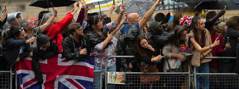 Vor dem Buckingham-Palast in London warten die Menschen auf die Queen. - Foto: Markus Schreiber/AP/dpa
